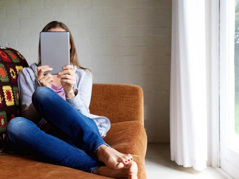 Woman reading an ebook on a sofa